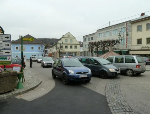 Blick über den Marktplatz von Schwertberg mit parkenden Autos und dem Festzelt im Hintergrund.