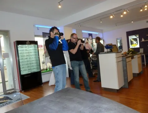 Zwei Fotografen bei der Arbeit im Verkaufsraum.