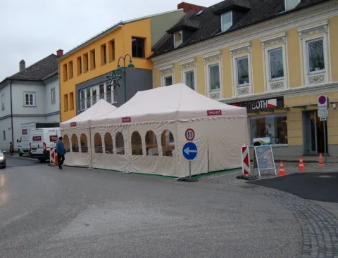 Zwei weiße Pavillons vor dem Geschäft, abgesperrt mit Leitkegeln.