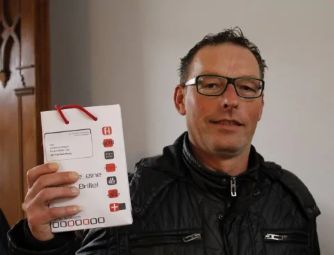 Ein Gast hält seinen gewonnenen Gutschein in die Kamera.