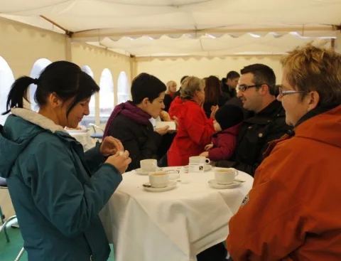 Gäste an Kaffeetischen im Festzelt.