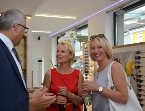 Drei Gäste mit Gläsern vor der Fassungswand
