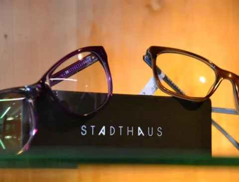 Eine Brille auf einem Etui mit der Aufschrift „Stadthaus“