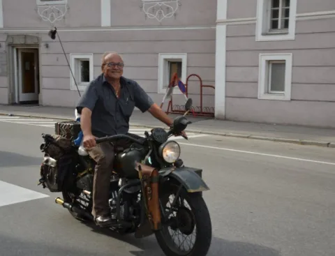 Ein Mann auf einem Motorrad vor dem Haus
