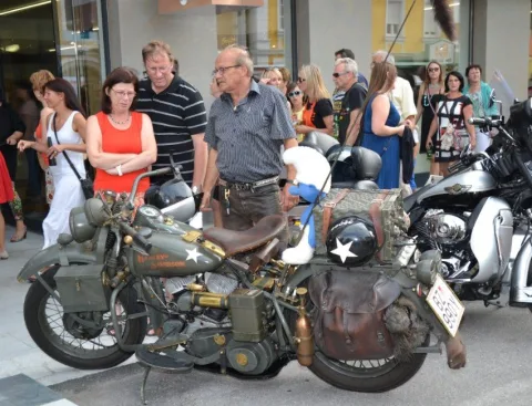 Motorräder vor dem Geschäft, dahinter Besucher