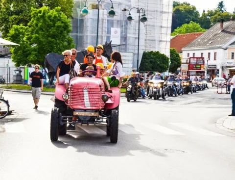 Ein Oldtimer führt einen Fahrzeugkorso durch den Ort an