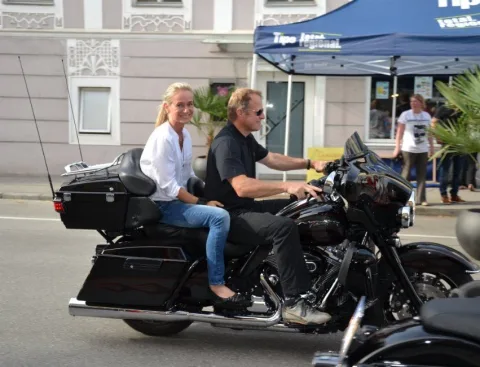 Zwei Personen auf einem Motorrad in der Ortsdurchfahrt