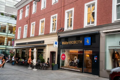 Das Geschäft „Stütz KROBOTH" in der Linzer Landstraße, rote Fassade mit Gastgarten davor