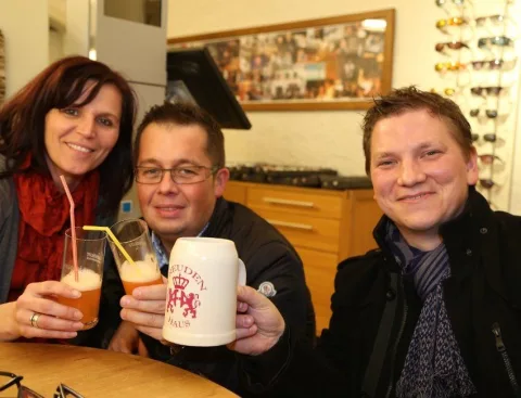 Ein Mann hält einen Bierkrug mit einem Löwen darauf