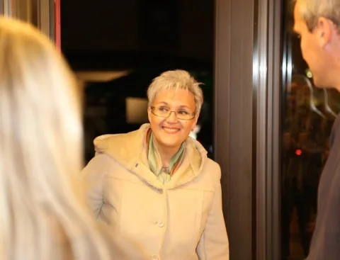 Eine Frau mit Brille steht lächelnd neben einem Mann.
