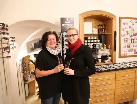 Zwei Frauen stehen nebeneinander in einem Optikergeschäft