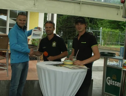 Drei Männer an einem Stehtisch auf der Terrasse des Clubhauses