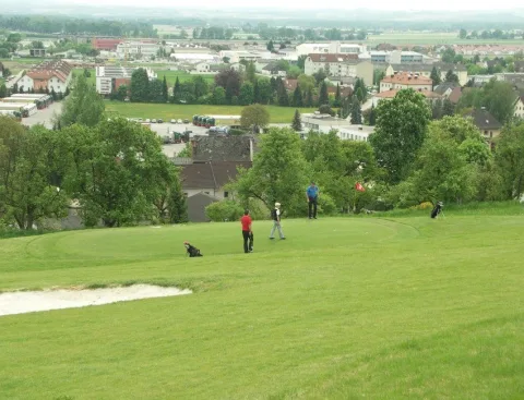 Blick über den Golfplatz auf den Ort im Tal