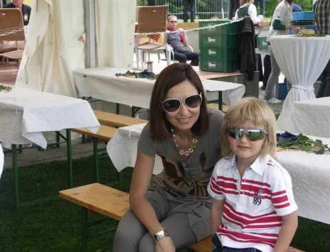 Eine Frau und ein Kind mit Sonnenbrillen auf einer Bank