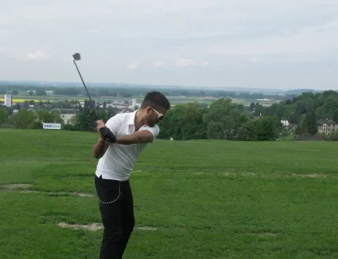 Ein Spieler beim Abschlag auf der Wiese