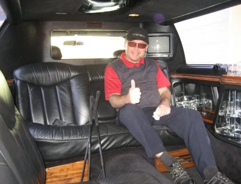 Ein Mann mit Kappe in einer Limousine