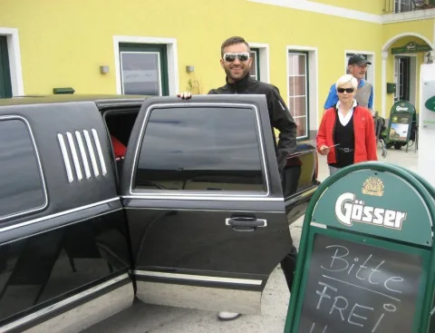 Die Limousine mit offener Tür neben einer Tafel