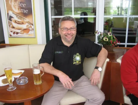 Ein Gast mit Glas auf einem Sessel im Clubhaus