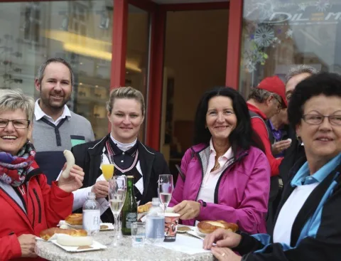 Fünf Gäste an einem gedeckten Tisch