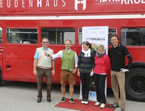 Vier Teilnehmer vor einem roten Doppeldeckerbus