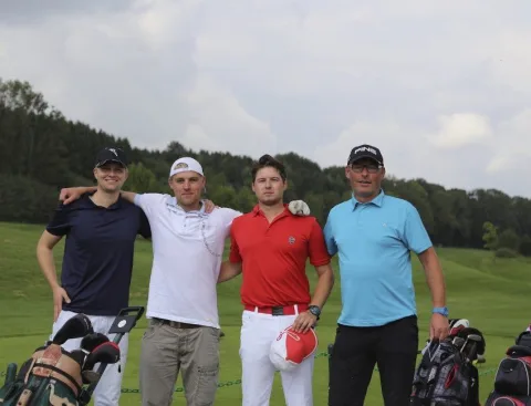 Vier Teilnehmer mit Golftaschen