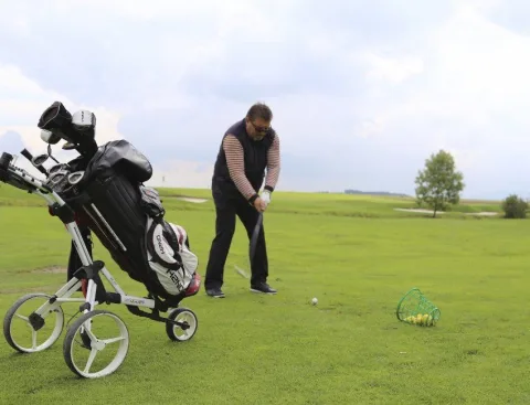 Ein Spieler mit Golfwagen auf dem Platz