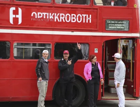 Vier Teilnehmer vor dem Doppeldeckerbus