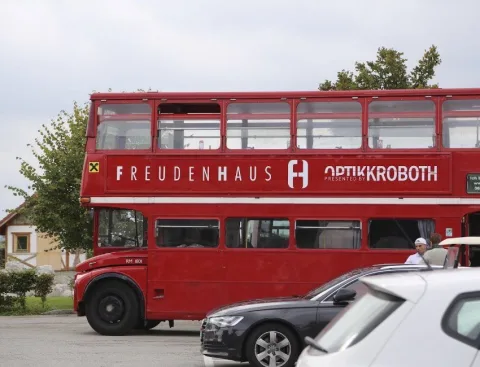 Der Doppeldeckerbus zwischen geparkten Autos