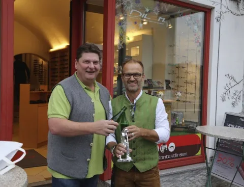 Zwei Männer mit einem Pokal im Geschäft