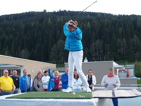 Eine Spielerin in blauer Jacke beim Abschlag