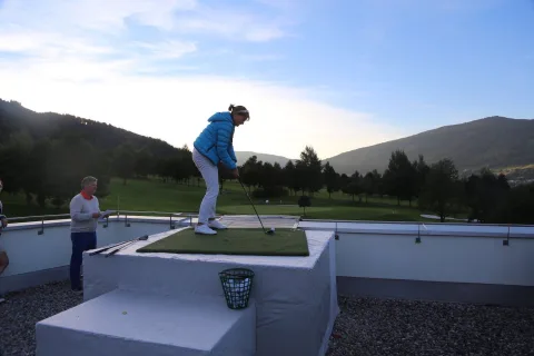 Ein Spieler in blauer Jacke beim Abschlag