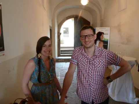Zwei Gäste im Gewölbegang vor einer Aufstellwand