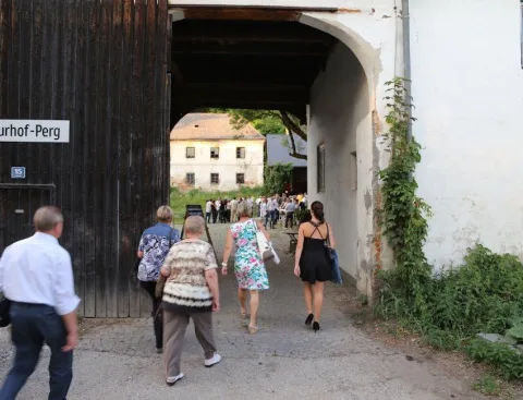 Besucher gehen durch das Hoftor