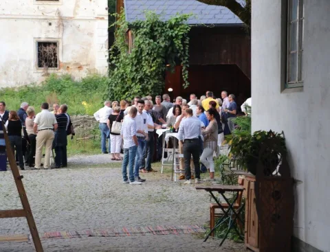 Gäste an Stehtischen im Hof