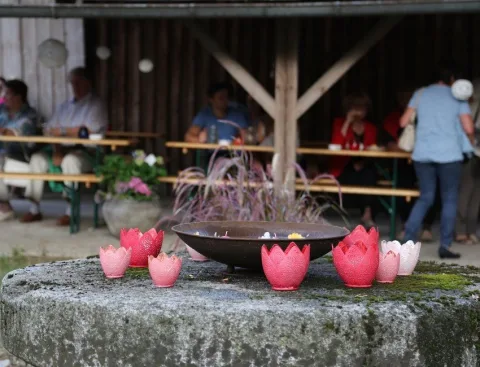 Ein Brunnen mit roten Windlichtern und Gästen dahinter