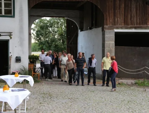 Gäste im Hof, davor ein leerer Stehtisch