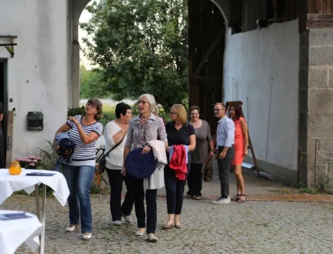 Besucherinnen an einem Stehtisch im Hof
