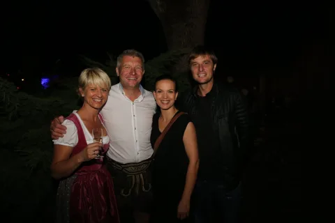 Vier Gäste im Gruppenbild, eine Frau im Dirndl