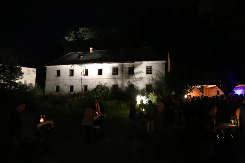 Das Hofgebäude bei Nacht, davor Gäste