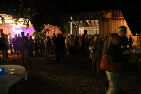 Gäste im Hof, dahinter violettes Licht