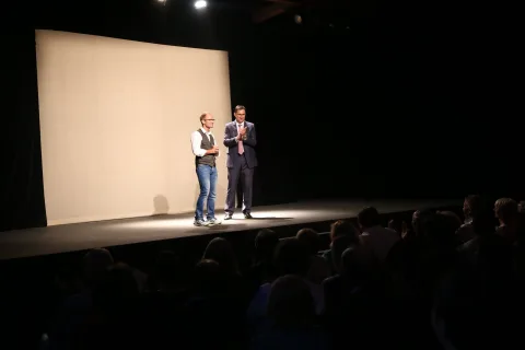 Zwei Darsteller vor der Leinwand