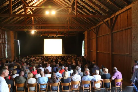Blick von hinten über das Publikum zur Leinwand