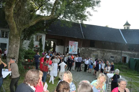 Besucher unter den Bäumen im Hof
