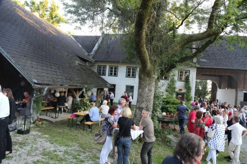Gäste zwischen Tischen im Hof