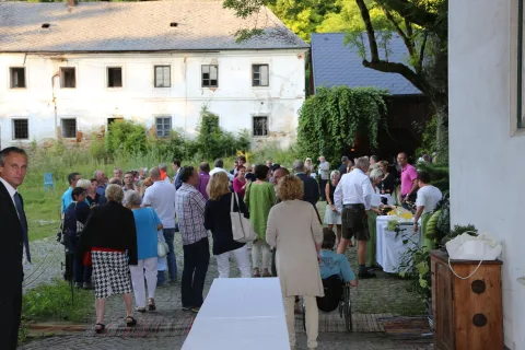 Gäste an einem Buffettisch vor dem Gutshof