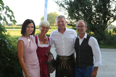 Vier Gäste im Gruppenbild, zwei in Tracht