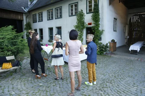 Besucher im Hof, eine Frau fotografiert