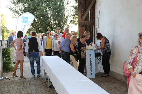 Besucher an einer langen weißen Tafel