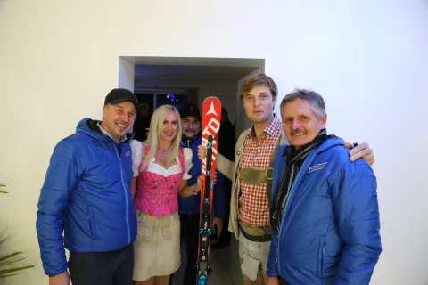 Vier Gäste mit einem Paar Ski neben der Tür.