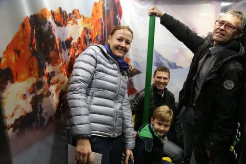 Vier Gäste, darunter ein Kind, am Fotopunkt vor der Bergkulisse.